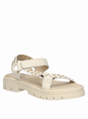 Sandalia de mujer beige en cuero premium, diseño con tachas y taco plano.