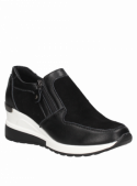 Zapatilla negra de cuero para mujer, con cremallera lateral y perfil bajo, adecuada para un look relajado y moderno.