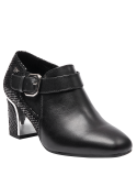 Moderno botín negro de cuero con tacón medio y diseño audaz, ideal para combinar con faldas tubo o vestidos.