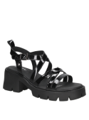 Sandalia negra de charol para mujer con tiras cruzadas y hebilla lateral, ideal para moda urbana.