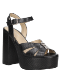 Sandalia de mujer en cuero negro con plataforma y detalles metálicos, combinable con vestidos y faldas veraniegas.