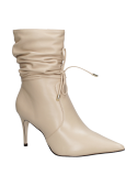 Botín de cuero beige con taco aguja, un complemento versátil para cualquier conjunto casual.