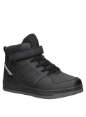 Zapatilla colegial negra de niño con diseño urbano, caña alta para soporte y velcro sobre cordones para ajuste seguro.