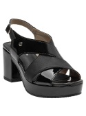 Sandalia moderna de cuero negro con detalle metálico decorativo en el diseño.