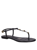 Calzado de cuero negro con diseño abierto y taco bajo, esencial para un look casual.
